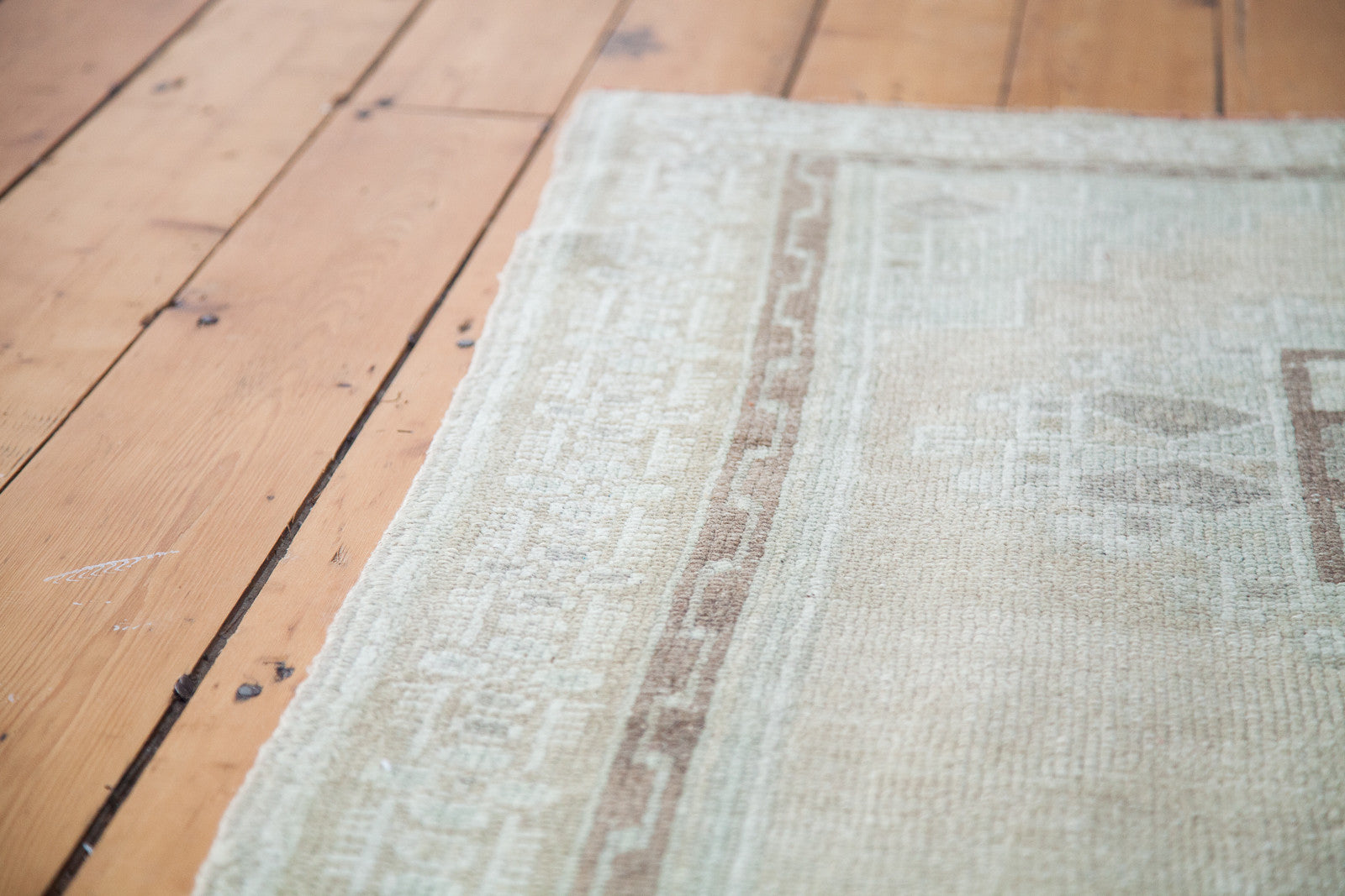 Vintage Oushak rug with pale geometric field and contrasting brown inner border.